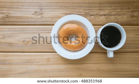 Dessert and drink image of donut or doughnut and hot coffee on vintage wooden table , Top view background