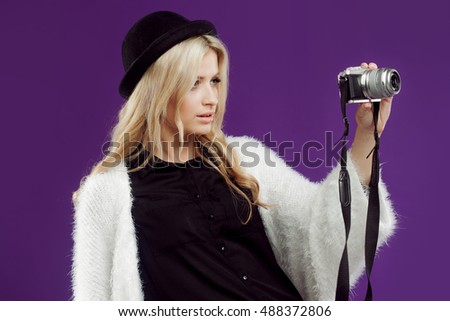 Fashion young girl makes the photo. Purple background. Photographer