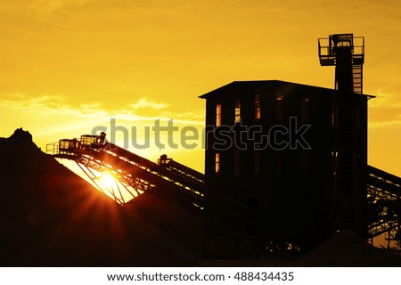 Smokestack in factory with yellow sky and sun flares. Industrial pollution.