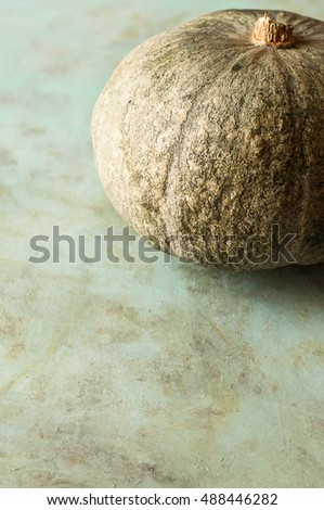 pumpkin on green wood base, vertical picture with empty space