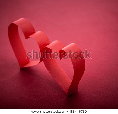 pictures concept theme Love and St. Valentine's Day - two beautiful romantic heart, made of paper tape in the shape of heart on a red paper background