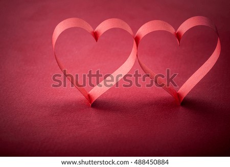 pictures concept theme Love and St. Valentine's Day - two beautiful romantic heart, made of paper tape in the shape of heart on a red paper background
