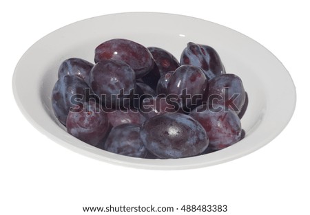 Plums in white plate isolated on white background