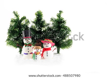 Winter scene of a three Snowmen family figures with fir trees and artificial snow isolated on white background 