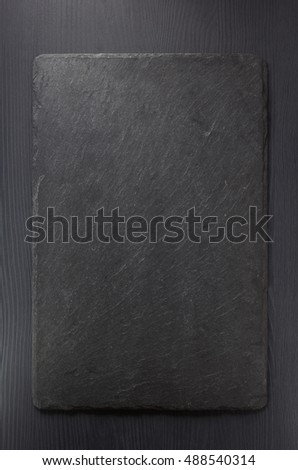 black slate stone on wooden background