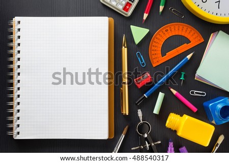 school supplies on black wooden background