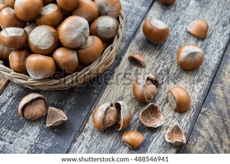 Hazelnut kernels and whole hazelnuts on old brown table, selective focus