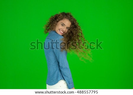 The young woman flirt and stand on the green background