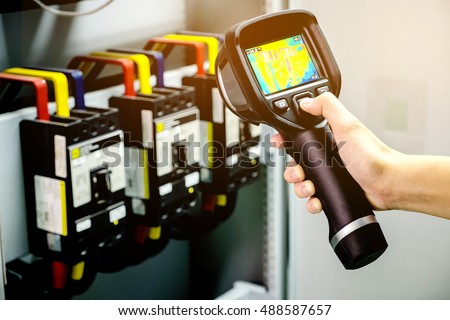technician use thermal imaging camera to check temperature in factory
