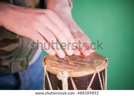 man drumming hands in studio. green background