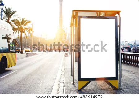 Empty billboard with copy space for your text message or promotional content, electronic advertising mock up, public information board outdoors on a bus stop, blank poster in urban setting 
