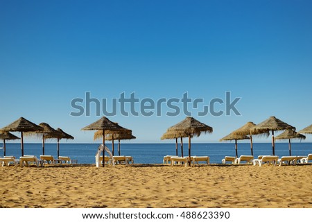 Blue sky and straw umbrella on a beautiful tropical beach background