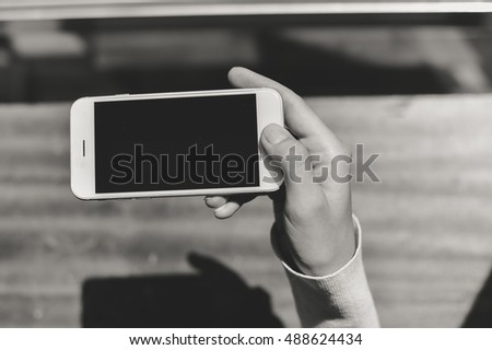 Black and white image closeup of smartphone in the hand, copy space background