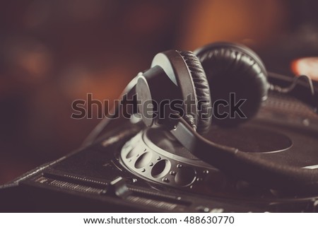 Dj headphones on cd player turntable. Professional disc jockey headset on concert stage. Play music on party in night club. Curated collection of royalty free music images and photos for poster design