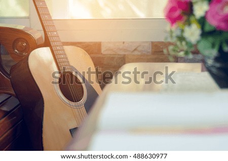 book and yellow pen on table with guitar background