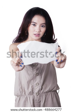 Portrait of a pretty teenage girl showing empty paper in the studio, isolated on white background