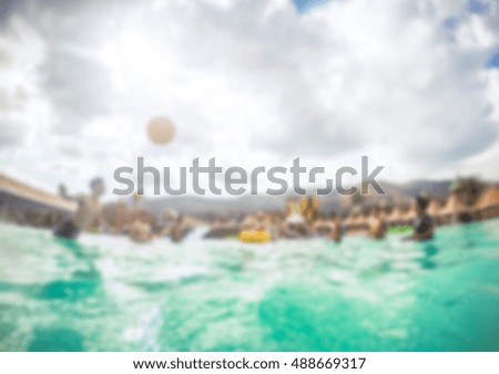 Blurred friends playing ball sport in waterpark