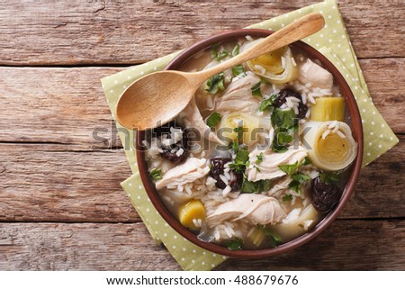 Scottish cock-a-leekie soup with leeks and prunes close up in a bowl on the table. Horizontal view from above
 Royalty-Free Stock Photo #488679676