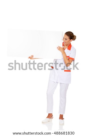 Happy female doctor or nurse holding empty banner