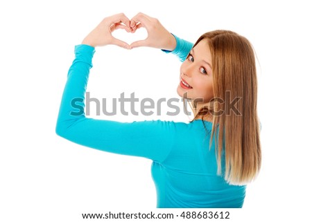 Smiling teenage woman making heart shape