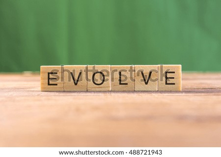 the word of EVOLVE on wood tiles concept