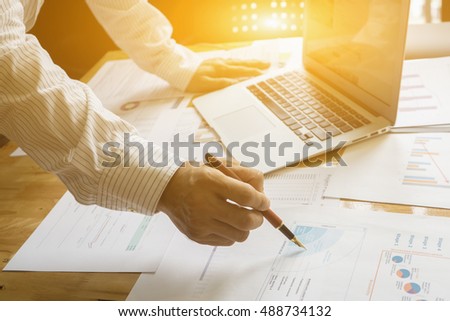 Person pointing writing goals on a paper,writing business plan at workplace,man holding pens and papers, making notes in documents, on the table in office,vintage color,morning light ,selective focus.