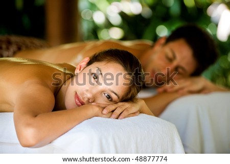An attractive young couple lying on massage beds at a spa outdoors Royalty-Free Stock Photo #48877774