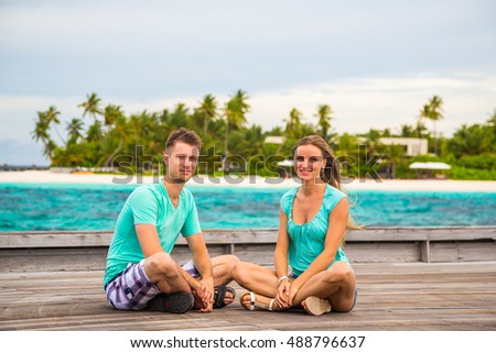 Romantic Couple sitting on the pier on a tropical island