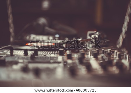 Dj turntable play music from vinyl record disc. Professional disc jockey setup on stage in nightclub. Retro djs turn table player needle on a record. Curated collection of royalty free music images