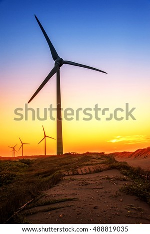 Wind turbines at sunset with gradient sky color.