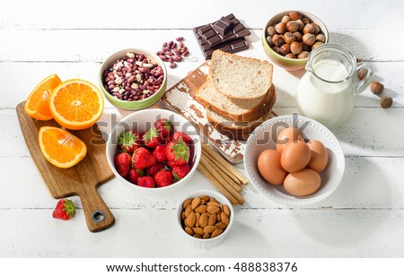Allergy food concept. Allergic food on a white wooden background. Top view Royalty-Free Stock Photo #488838376