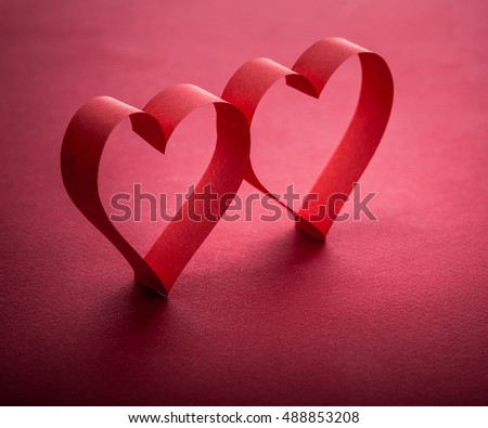 two beautiful romantic heart, made of paper tape in the shape of heart on a red paper background - pictures concept theme Love and St. Valentine's Day
