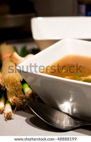 A bowlful of chicken broth soup with ingredients