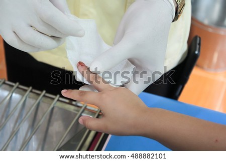 Doctor makes bandage on finger at public health center
