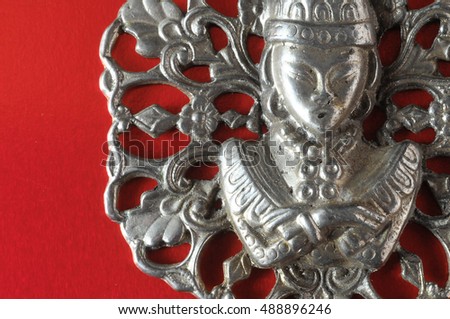 Silver Buddha Pendant Jewel over a Colored Background