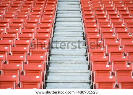 row of empty orange step seats in stadium with numbers