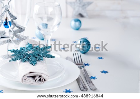 Christmas table setting in blue colors with fir tree and toys