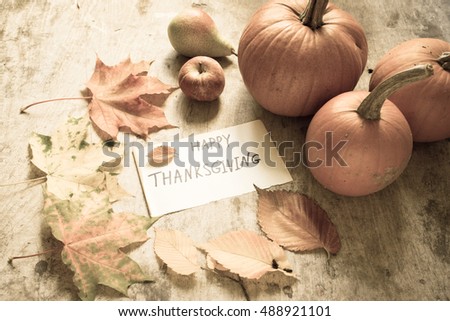 Autumn leaves and pumpkins on a wooden background/Thanksgiving day concept/toned photo