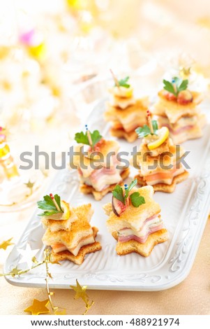 Star shaped toasts with smoked salmon, ham and cheese. 