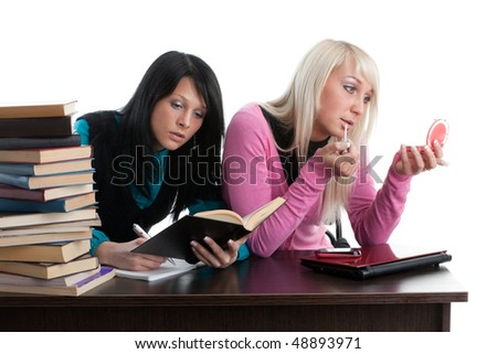 Two girlfriends of the student prepare for examination, sitting at a table on a white background. Royalty-Free Stock Photo #48893971