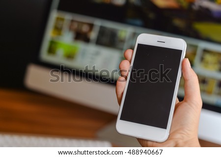Closeup of smartphone in the hand on office background