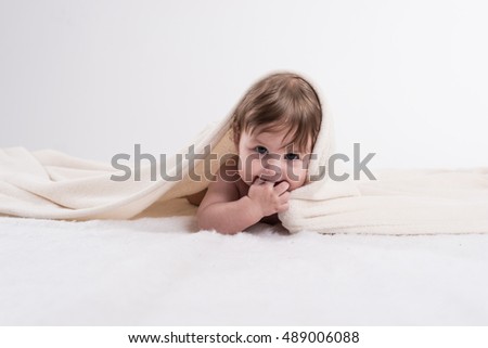 Happy baby under blanket advertising photography.