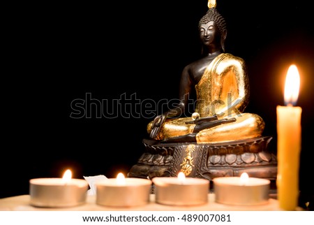 Buddha statue and light candle with light dark background . buddha image used as amulets of Buddhism religion.