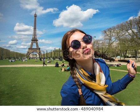  Cheerful smiling woman tourist at Eiffel Tower smiling and making travel selfie. Beautiful European girl enjoying vacation in Paris, France Royalty-Free Stock Photo #489040984