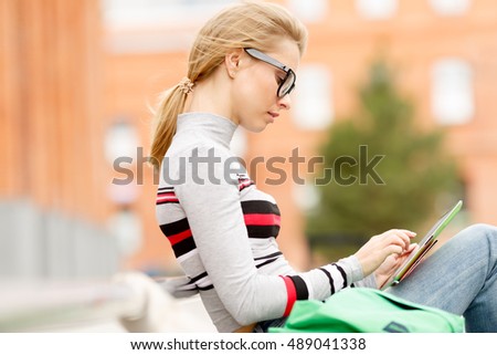 girl with tablet in their hands on street