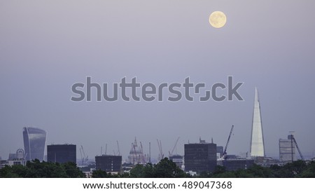 Skyline of the city of London at night with full moon on the top of Shard building from Primrose Hill