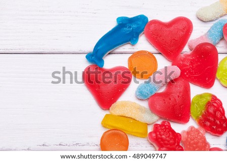Colorful sweet jelly candies on a white wooden background. With copy space