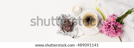 Cup of black coffee, Bouquet of pink flowers, Chocolate and Empty paper sheet on white background, Beautiful card, Top view, Long web format, flat lay concept