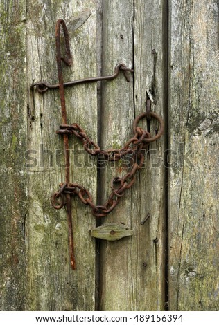 Vintage rusty locks close the old wooden door