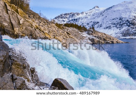 Beautiful blue water under snowy mountains in Norway